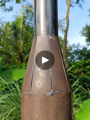 a close up of a metal object with trees in the background