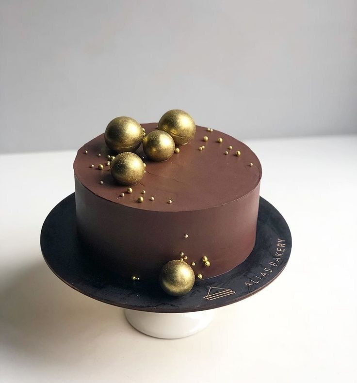 a chocolate cake with gold decorations on top