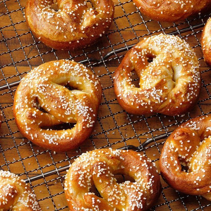 several donuts sitting on a cooling rack with sugar sprinkled on the top