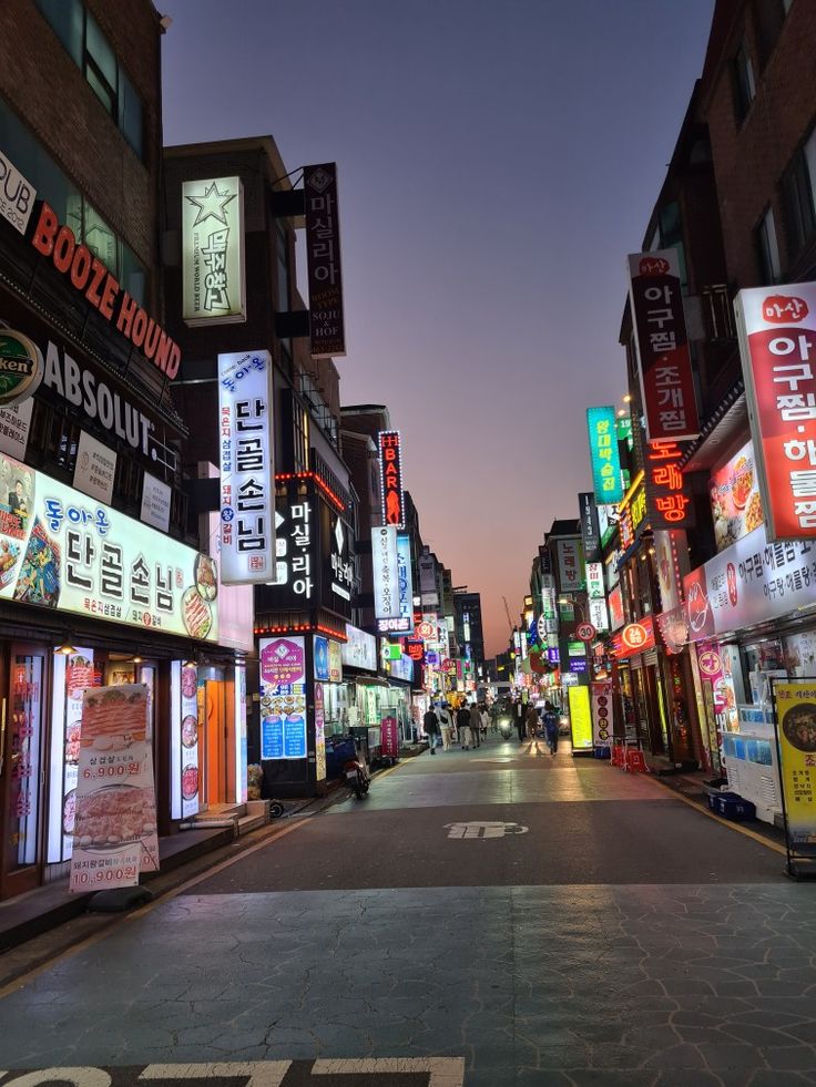 an empty city street at night with neon signs