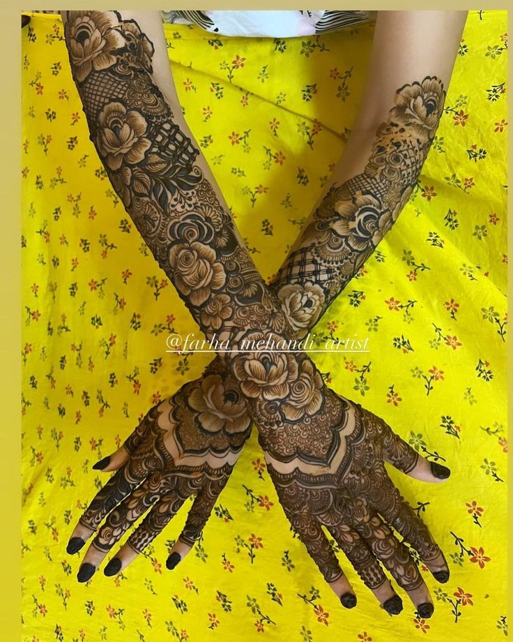 a woman's hands with hennap and flowers on her arm, showing the intricate