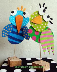 two colorful paper birds sitting on top of each other