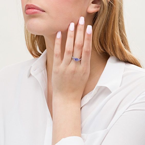 The perfect mix of classic and modern, this gemstone and diamond bridal set is the unique look she's been searching for. Created in 14K white gold, the three-stone engagement ring showcases a trio of cushion-cut violet-blue tanzanites - the largest the 6.0mm center stone. Diamonds adorn the shank for a sparkling style. On your wedding day, complete her ensemble with the contoured diamond-lined band. Radiant with 1/4 ct. t.w. of diamonds and a brilliant buffed luster, this bridal set shines with Trillion Cut Tanzanite White Gold Jewelry, Trillion Cut Tanzanite Jewelry In White Gold, Formal Tanzanite Jewelry With Diamond Accents, Classic Tanzanite Diamond Ring In White Gold, Tanzanite White Gold Diamond Ring With Brilliant Cut, White Gold Tanzanite Diamond Ring With Brilliant Cut, Elegant Diamond Ring With Lab-created Sapphire And Accent Stones, Classic Tanzanite Jewelry In Trillion Cut, Brilliant Cut Tanzanite Diamond Ring In White Gold