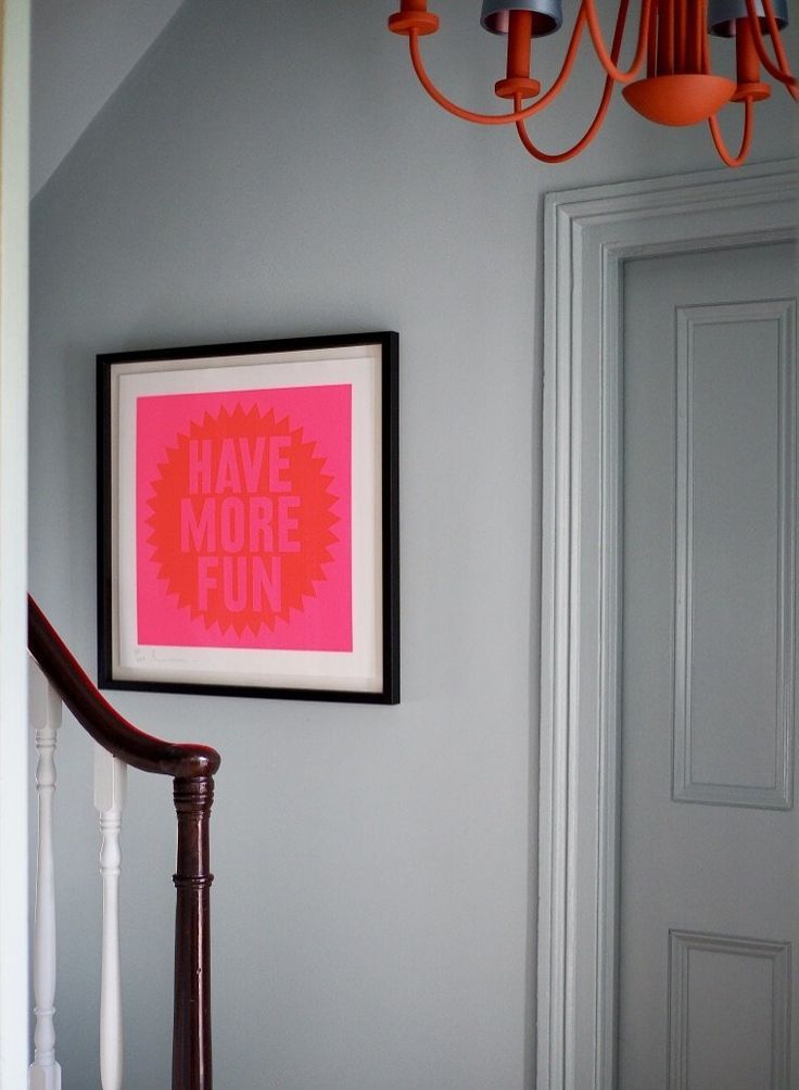 a pink poster hanging on the wall above a banister