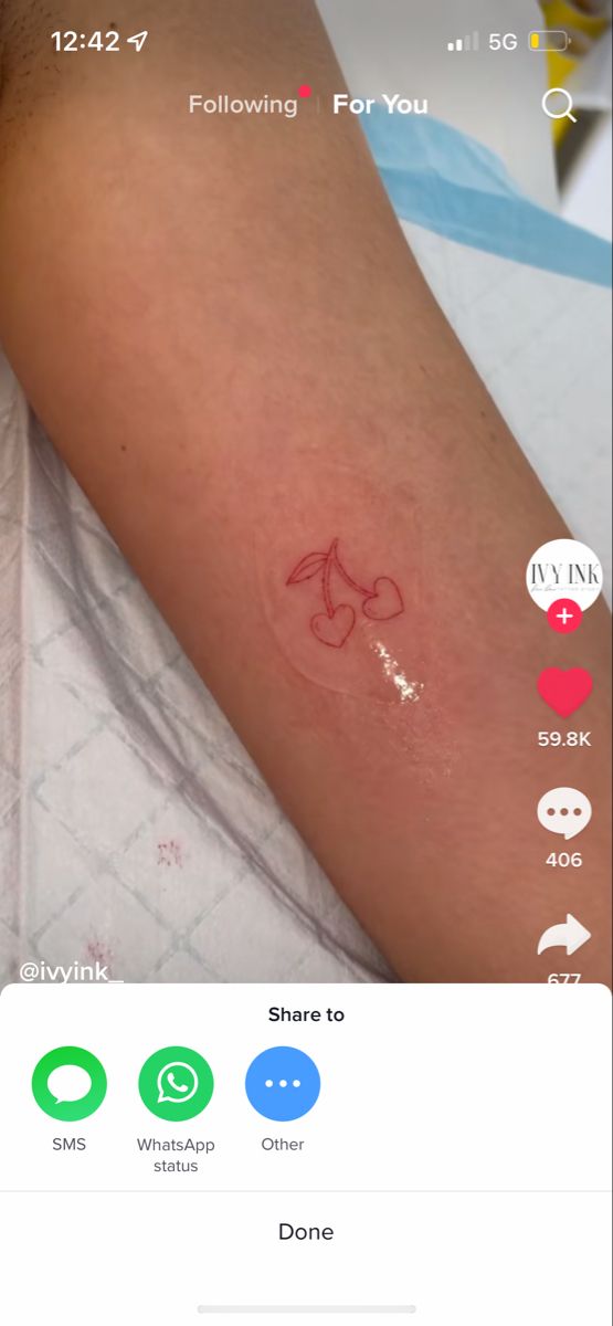 the tattoo on someone's arm is red and has an arrow drawn on it