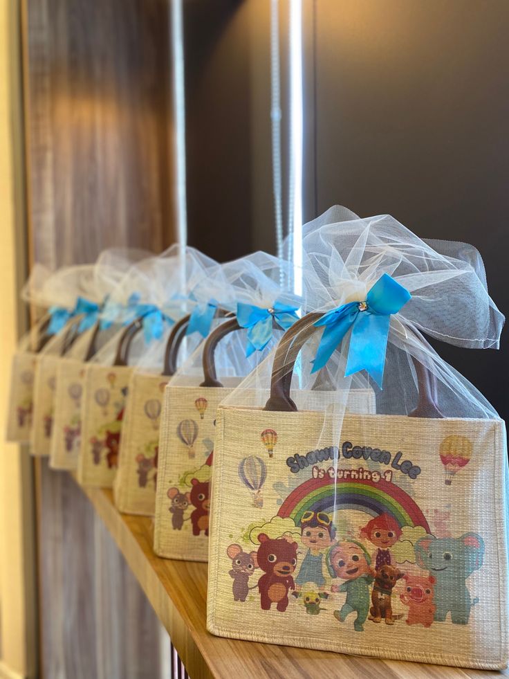 four bags with cartoon characters on them are hanging from the wall in front of a door