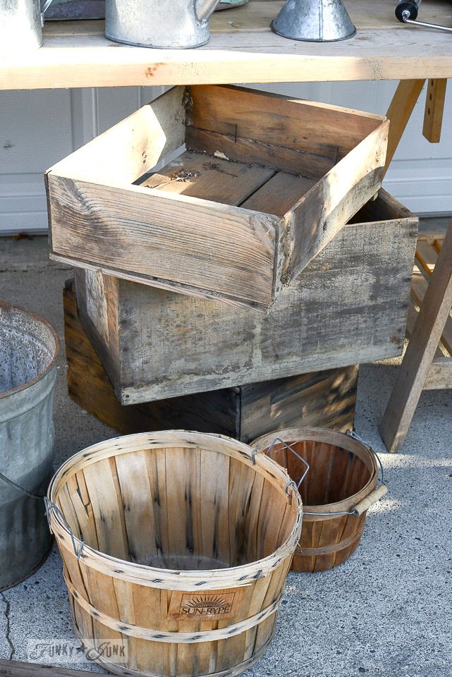 three wooden buckets sitting next to each other on the ground near a table and chair