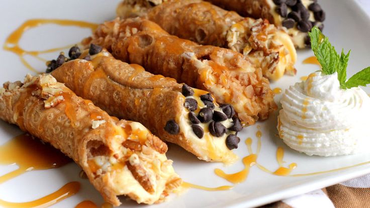 some food is sitting on a white plate with ice cream and chocolate chips around it