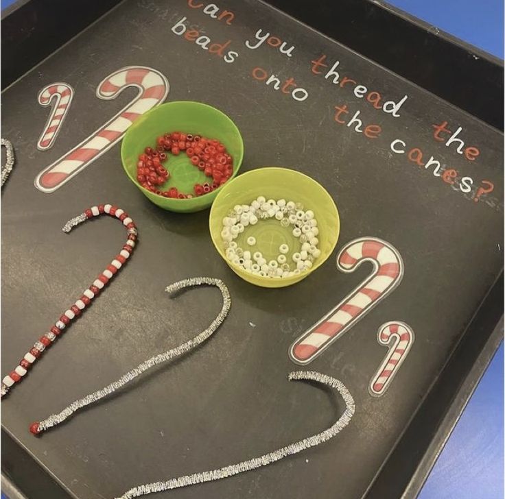 a tray with candy canes and two bowls filled with food on top of it