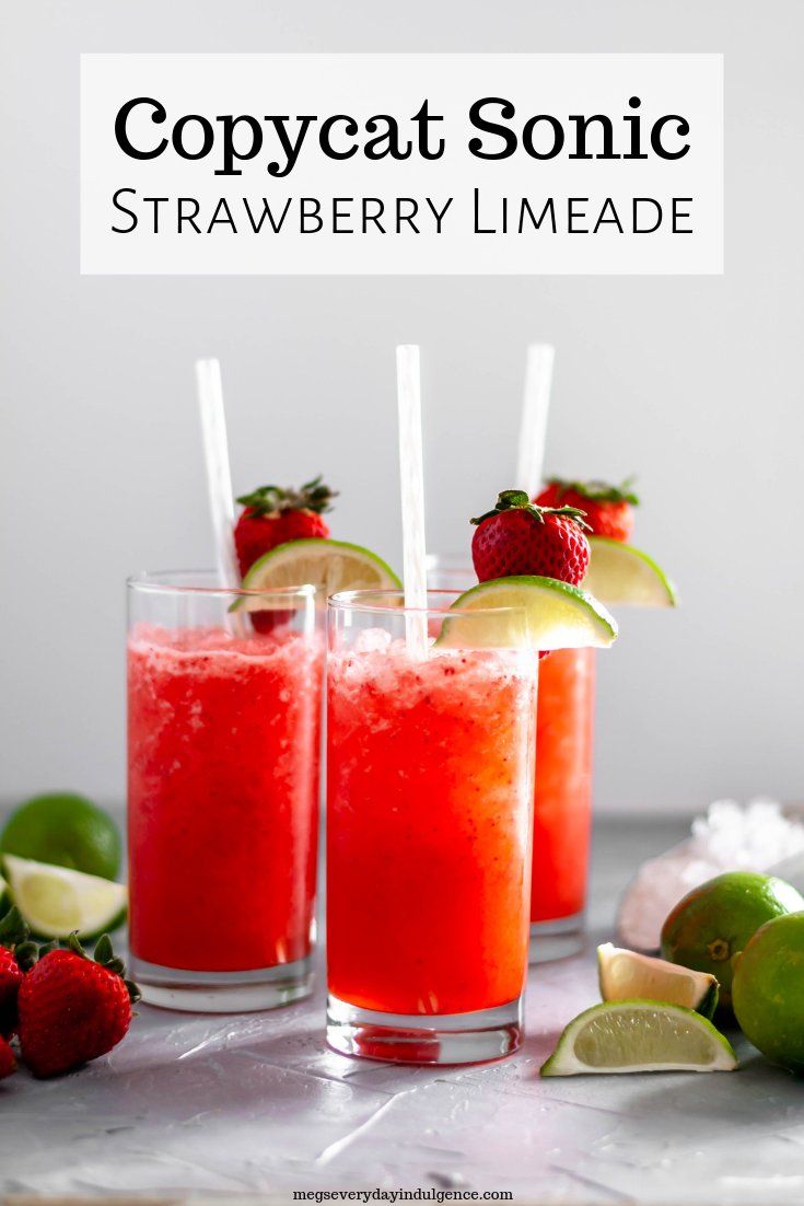 two glasses filled with strawberry limeade and topped with strawberries