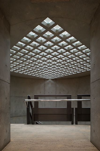 an empty building with a skylight and stairs leading up to the top floor in front of it