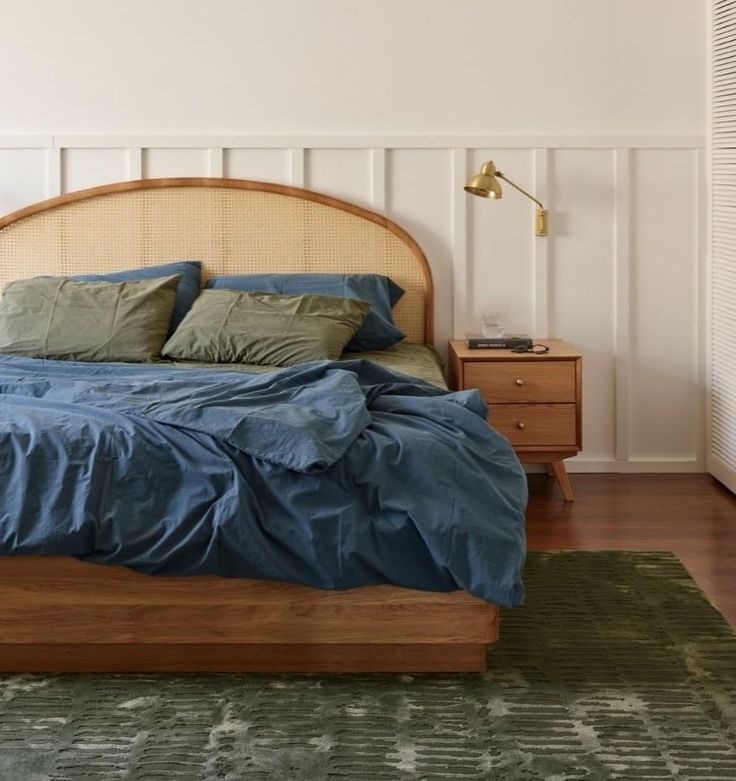 a bed with blue sheets and pillows in a bedroom