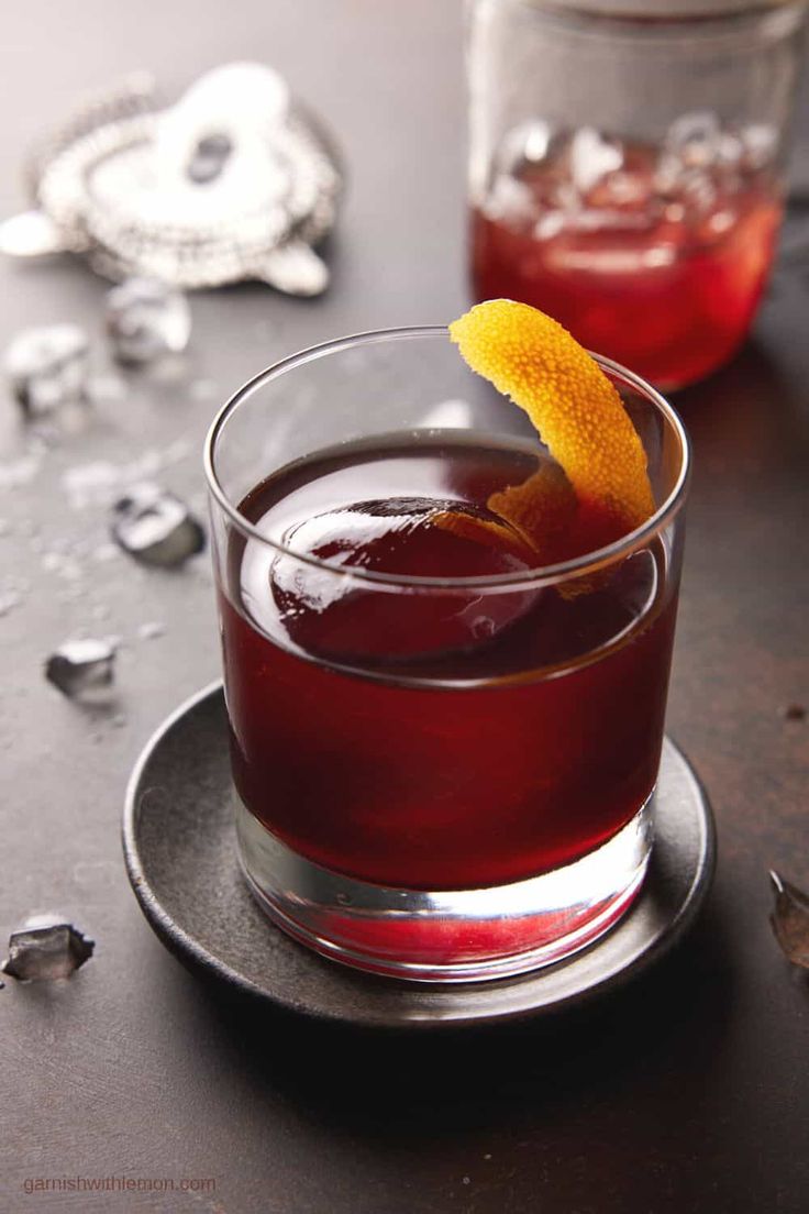 a close up of a drink on a plate with an orange peel in the middle