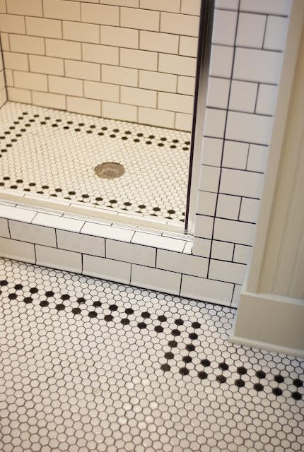 a bathroom with black and white tile on the floor, shower stall door and toilet