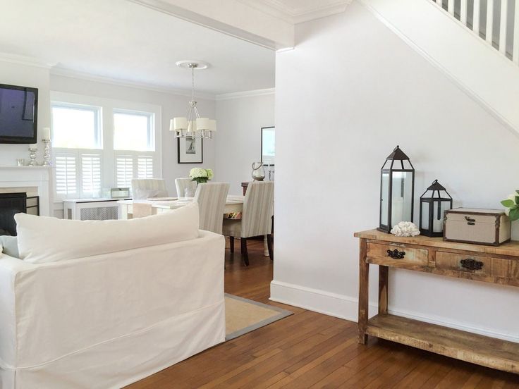 a living room with white furniture and wooden floors