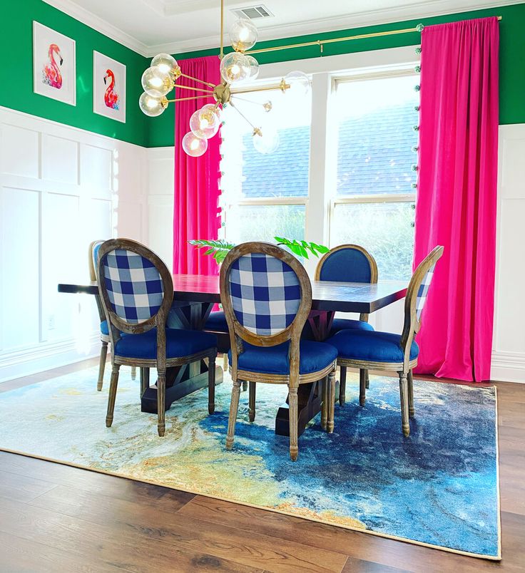 a dining room with pink curtains and blue chairs