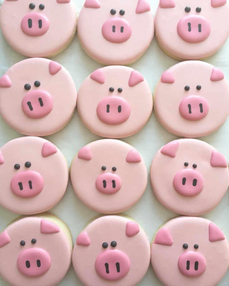 some pink and black decorated cookies with pig faces on them are arranged in the shape of pigs