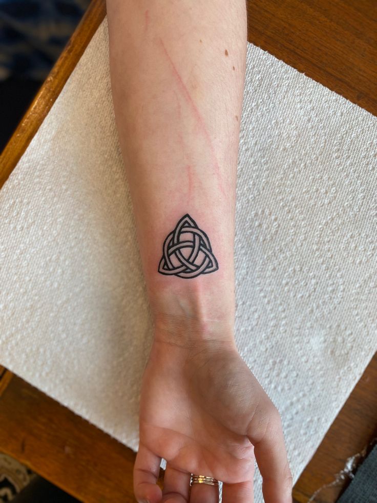 a person's arm with a tattoo on it and a ring around the wrist