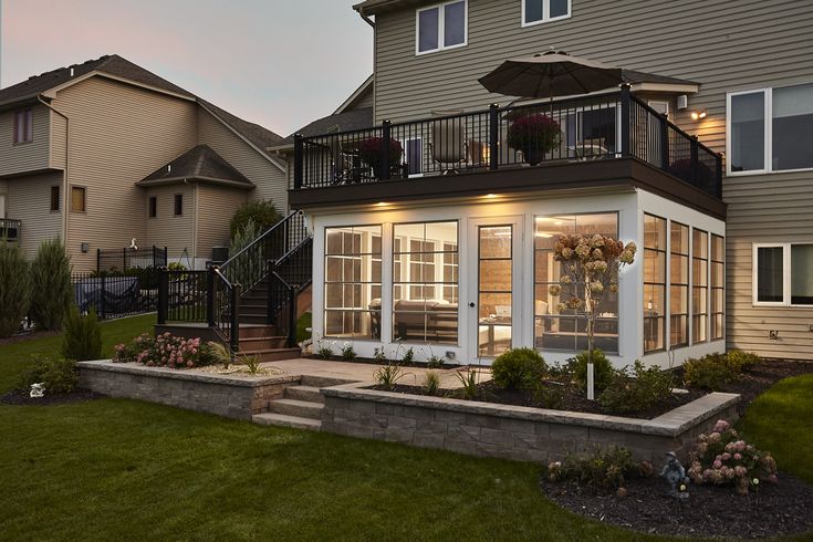 a house that has some plants in front of it and an umbrella over the porch