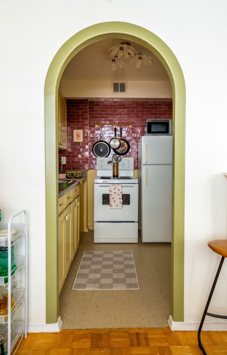 an archway leading into a kitchen with white appliances