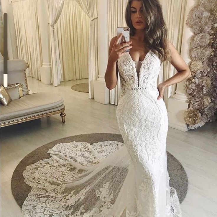 a woman is taking a selfie in her wedding dress while standing on the floor