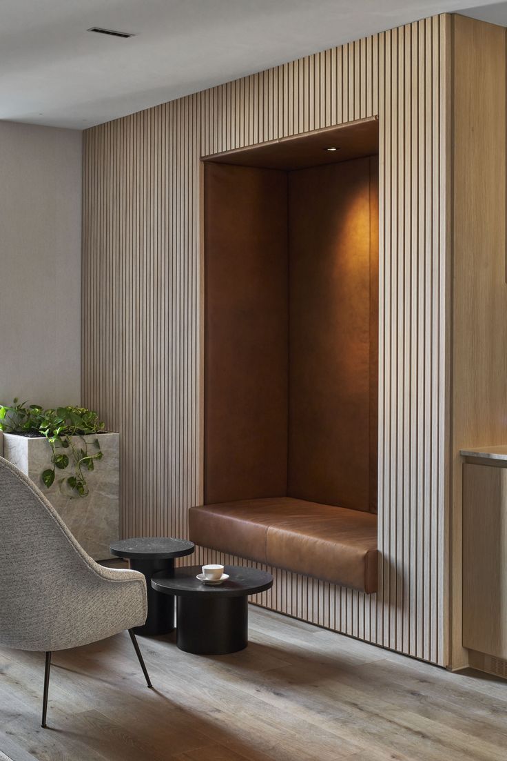 an empty room with a chair, table and potted plant on the side wall