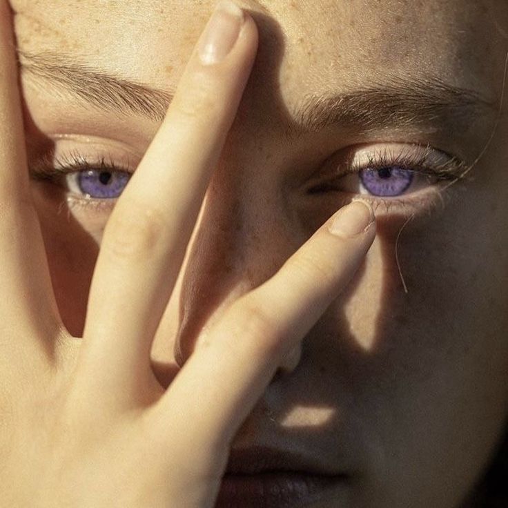 a close up of a person holding their hands to their face with the sun shining on them