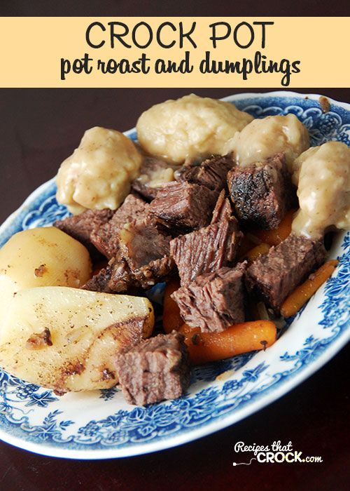 a blue and white plate topped with meat, potatoes and gravy on top of a wooden table