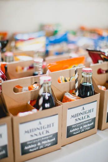 several boxes filled with different types of beverages on top of a white tablecloth covered table