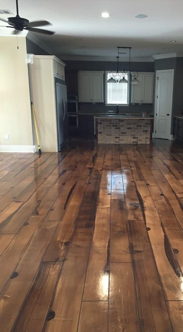 an empty kitchen and living room with hard wood flooring in the middle of it