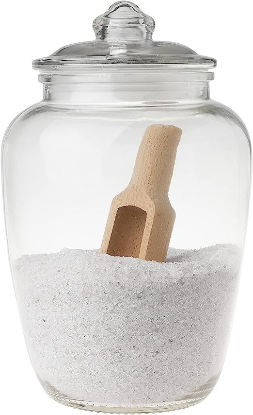 a glass jar filled with sand and a wooden spoon