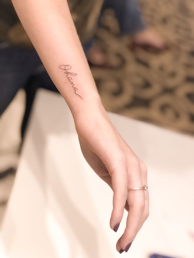 a woman's hand with the word love tattooed on her left wrist and finger