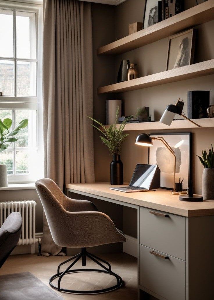 a desk with a chair, lamp and bookshelf in front of a window