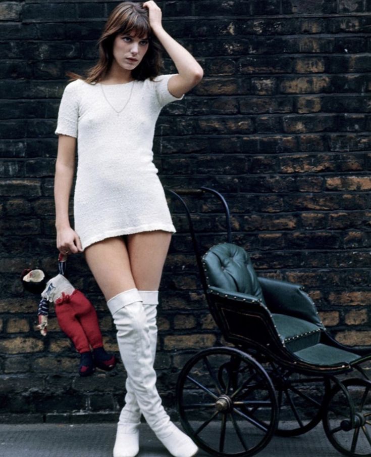 a woman standing next to a baby carriage