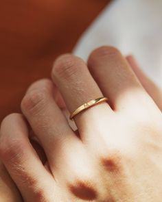 a woman's hand with a gold ring on it