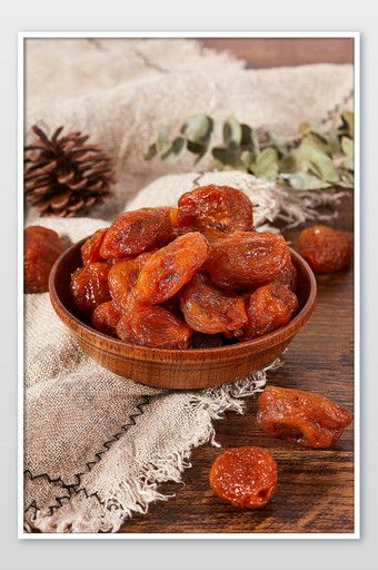 a wooden bowl filled with dried fruit on top of a table