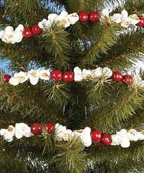 a christmas tree decorated with white and red ornaments on it's branches, in front of a blue sky