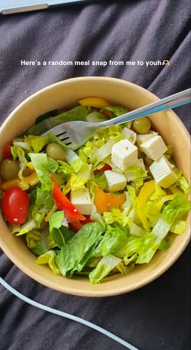 a salad in a bowl with a fork and knife