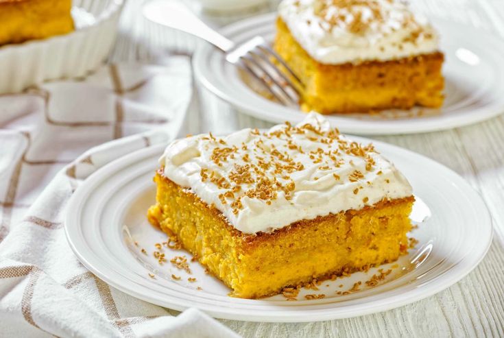 two white plates topped with slices of cake and frosting on top of each other