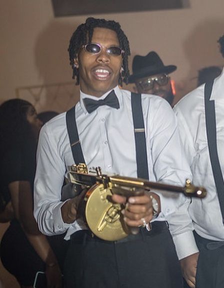 two men in white shirts and black suspenders holding brass instruments