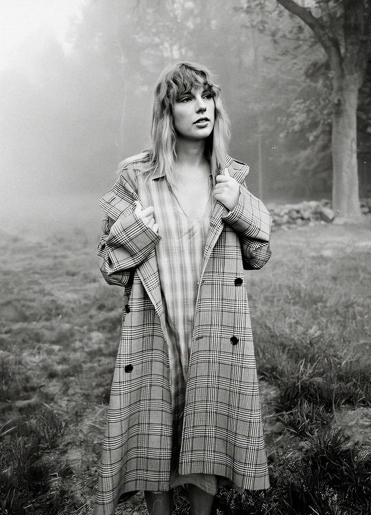 a woman standing in the grass with her hands on her hips