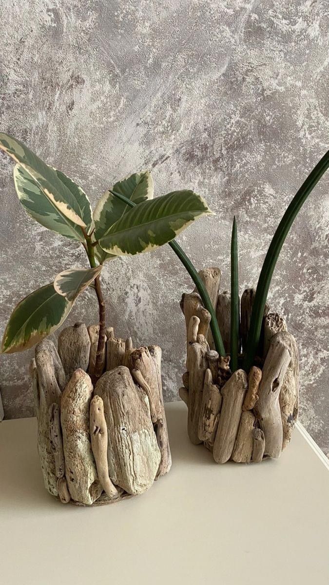 two planters made out of driftwood are sitting on a table next to each other