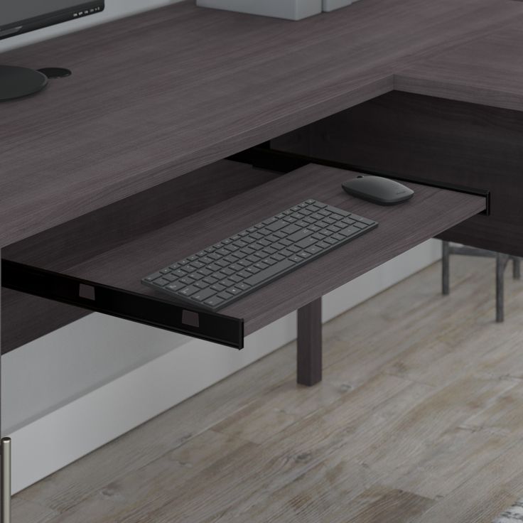 a computer desk with a keyboard, mouse and monitor sitting on it's side