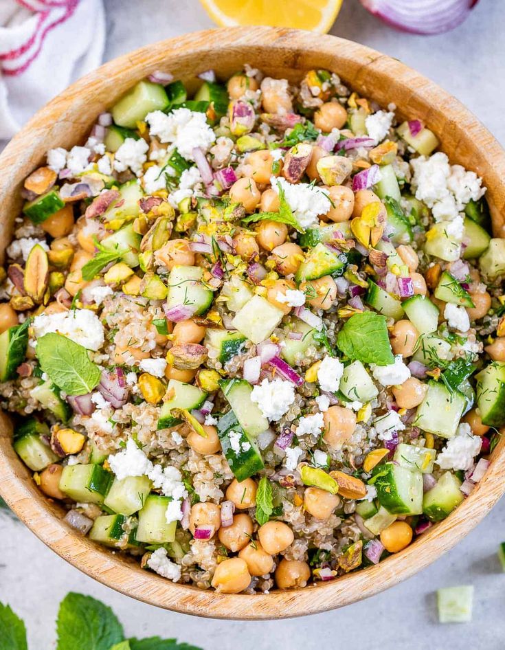 a salad with cucumber, chickpeas and feta cheese in a wooden bowl