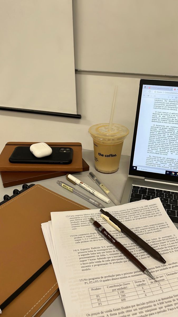 an open laptop computer sitting on top of a desk next to a cup of coffee