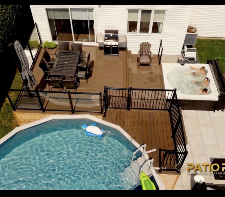 an aerial view of a backyard with a hot tub, deck and patio furniture in the background