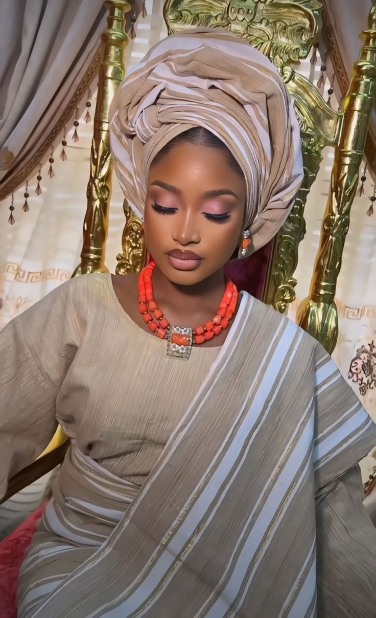 a woman sitting in a chair wearing a turban and beads on her head