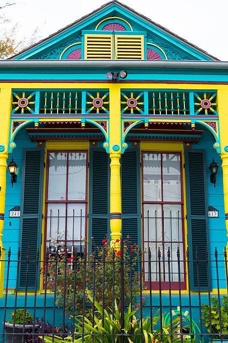 a blue and yellow house with green shutters