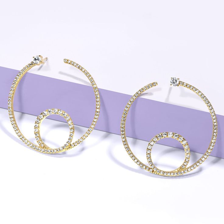 The Shimmering Loop Bardot Hoops are artistic and minimalistic. They're made with solid gold and ethically sourced natural diamonds, adding a touch of shimmer to any outfit. The loop design adds an element of movement to the hoops, making them a dynamic addition to your jewelry collection. Gold Circular Diamond Jewelry, Gold Diamond Circle Jewelry, Modern Open Circle Wedding Jewelry, Modern Gold Earrings With Sparkling Stones, Modern Sparkling Jewelry For Formal Occasions, Modern Circle Jewelry With Diamond Accents, Elegant Hoop Rhinestone Jewelry, Modern Circular Jewelry With Diamond Accents, Elegant Hoop Earrings With Rhinestones