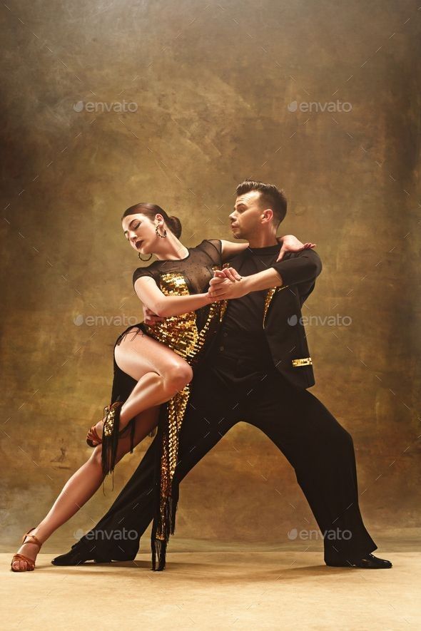 a man and woman dancing salsa in front of a brown background - stock photo - images